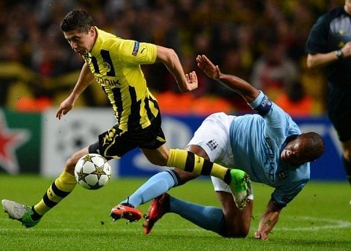 Borussia Dortmund's Robert Lewandowski (L) vies with Manchester City's Vincent Kompany